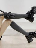 Detail shot of grey knee-high socks with a playful bunny charm, highlighting the texture and fit.