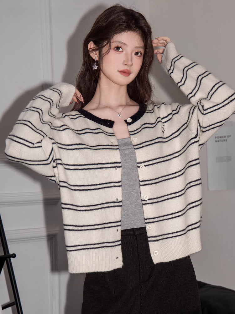 Front view of a woman in a striped knit cardigan, showing the button closure and contrast trim.