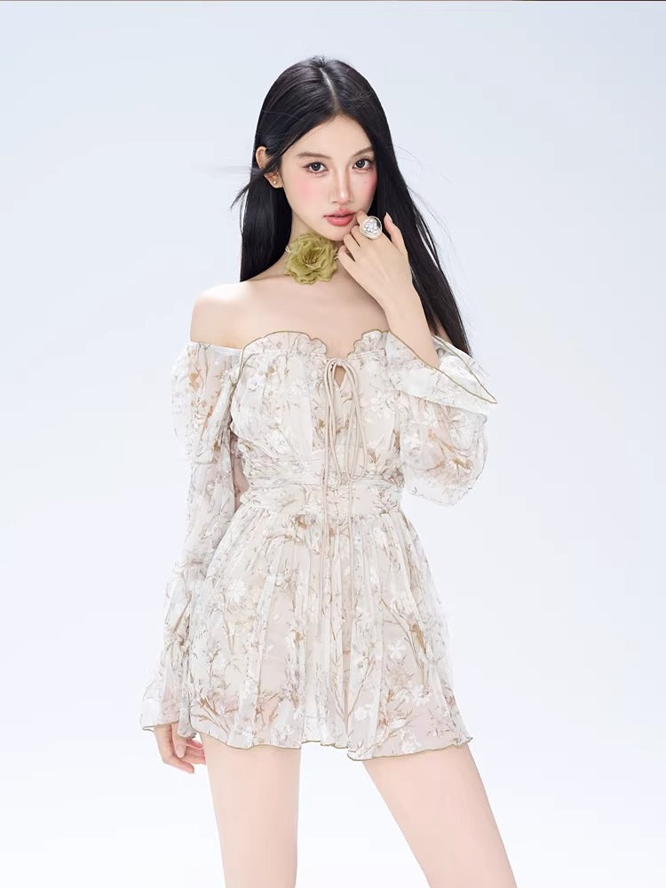 Woman wearing a white off-the-shoulder mini dress with a delicate floral print and long bishop sleeves.