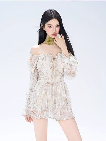 Woman wearing a white off-the-shoulder mini dress with a delicate floral print and long bishop sleeves.