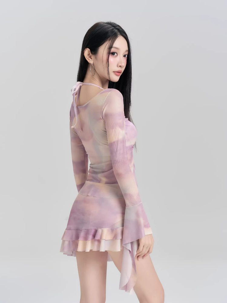 Rear view of a woman in a lavender and peach tie-dye mesh long sleeve mini dress