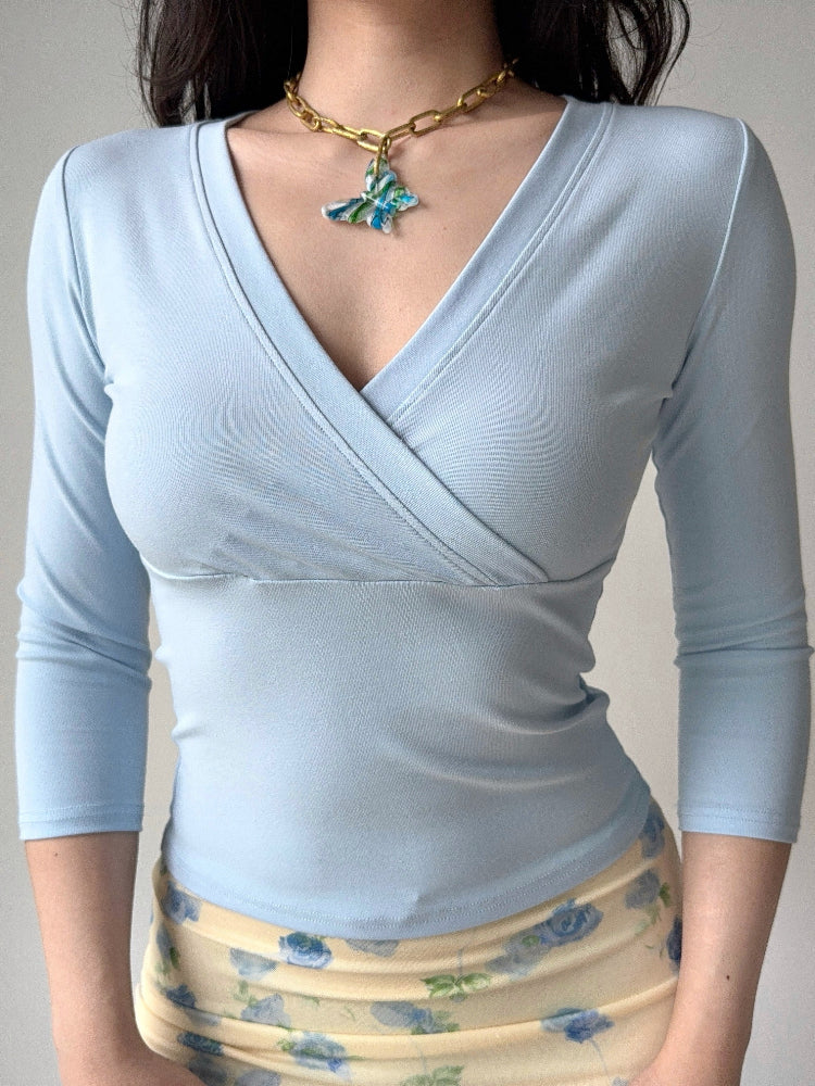 model wearing a light blue wrap top and floral skirt