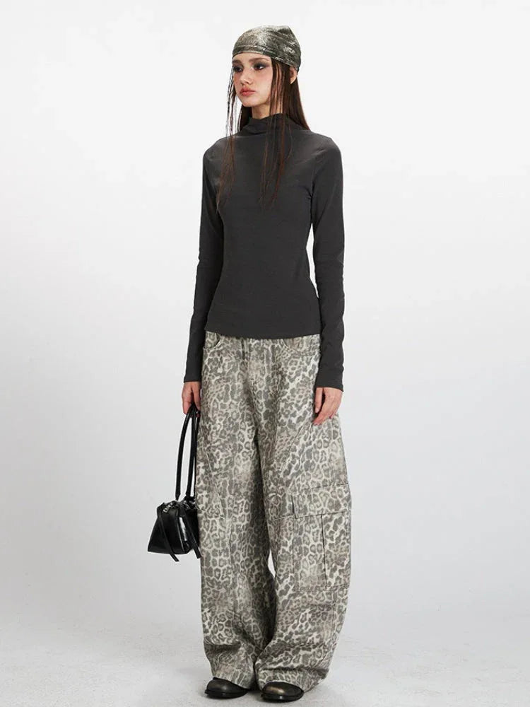Model wearing a dark grey mock neck long sleeve top and patterned wide-leg pants.