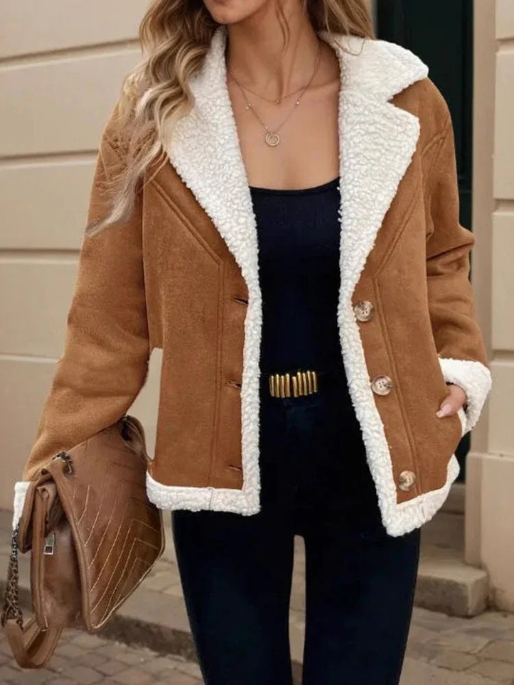Close-up of the front of a brown suede-like jacket with white sherpa collar and cuffs.