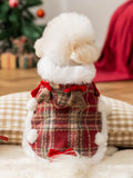 Back view of a white dog in a festive red plaid pet coat with faux fur trim and antler details
