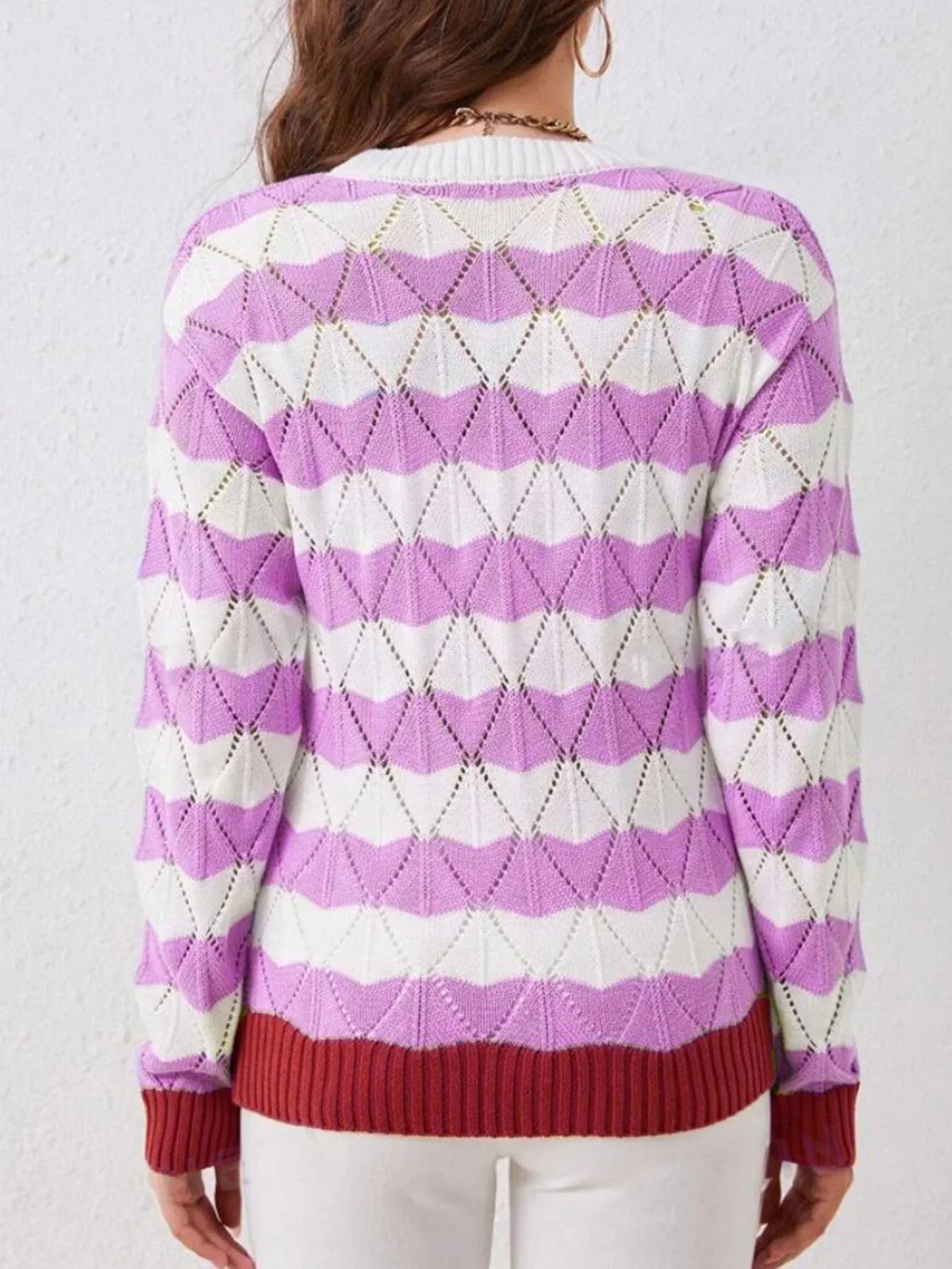Back view of a woman in a white and lavender geometric knit sweater.