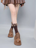 Full view of brown ribbed socks with butterfly details and a ruffled top, worn with brown lace-up platform shoes and a skirt.