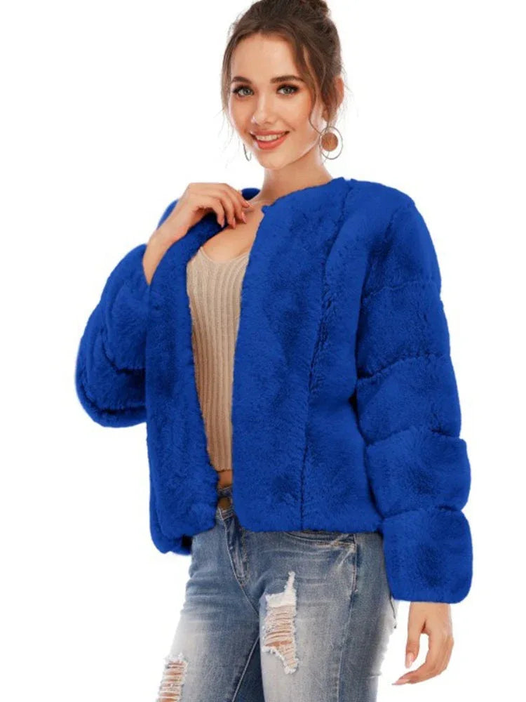 Model posing in a royal blue faux fur jacket and ripped jeans.