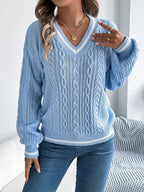 Woman adjusting her sweater, showing the v-neck and cable knit details