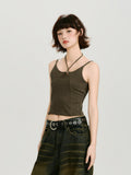 Side profile of a model wearing a dark olive green halter neck crop top with a cut-out detail and metal ring accent.