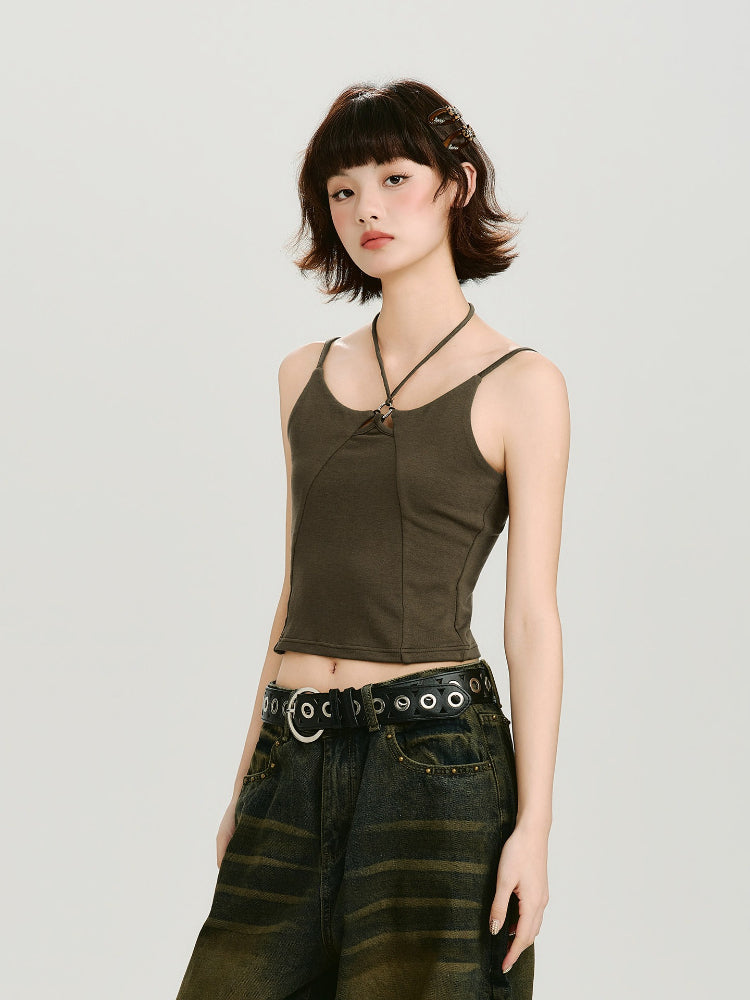 Side profile of a model wearing a dark olive green halter neck crop top with a cut-out detail and metal ring accent.