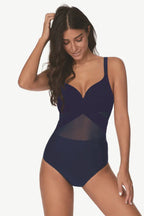 Woman wearing a navy blue one-piece swimsuit with mesh accents and a criss-cross neckline