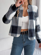 Front view of a woman in a navy, white, and grey plaid jacket with an open neckline.