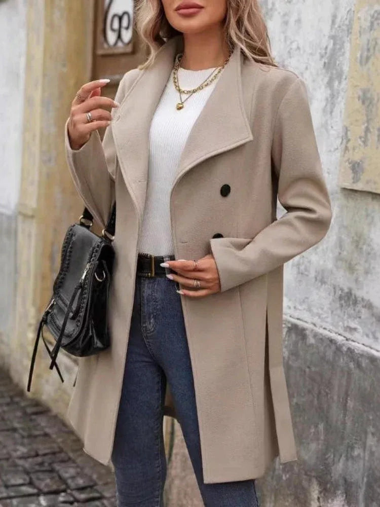 Woman holding a black handbag and wearing a beige wool blend coat with notch lapel