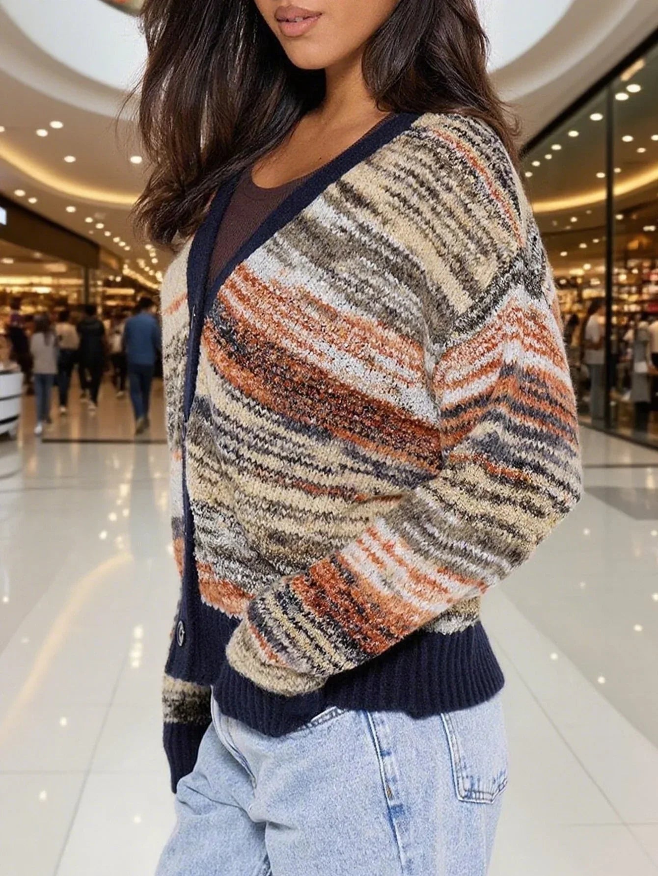Side view of a woman wearing a multicolored striped knit cardigan with a V-neck and button-up front