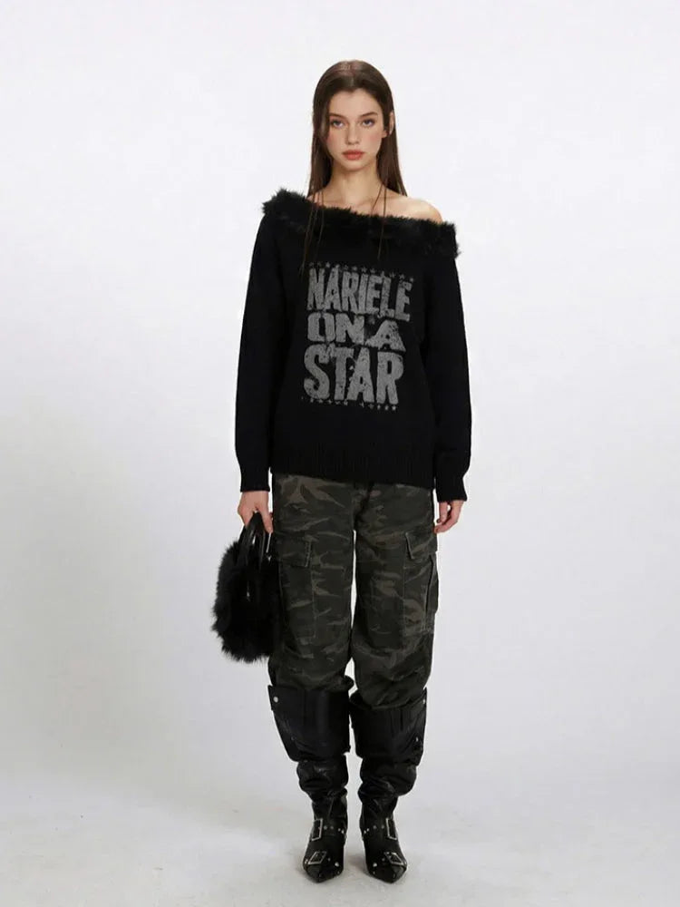Woman wearing a black off-the-shoulder knit sweater with faux fur trim and a "NARIELE ON A STAR" graphic print, paired with camouflage cargo pants and black boots. Main image