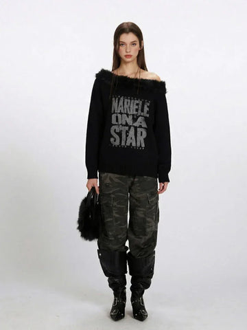 Woman wearing a black off-the-shoulder knit sweater with faux fur trim and a "NARIELE ON A STAR" graphic print, paired with camouflage cargo pants and black boots.