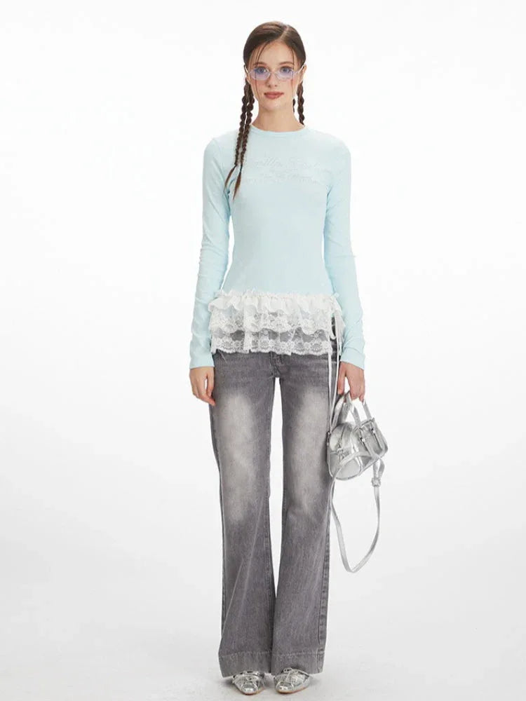 Woman wearing a light blue long-sleeve top with white lace trim and grey wide-leg jeans