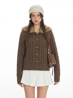Woman posing in a brown knit cardigan with a furry collar and a brown crossbody bag.