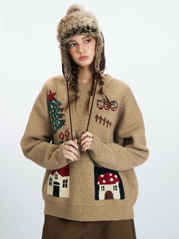 Front view of a woman in a tan knit sweater with graphic details and a winter hat