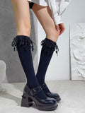 Close-up of black ankle socks with decorative lace and star details.