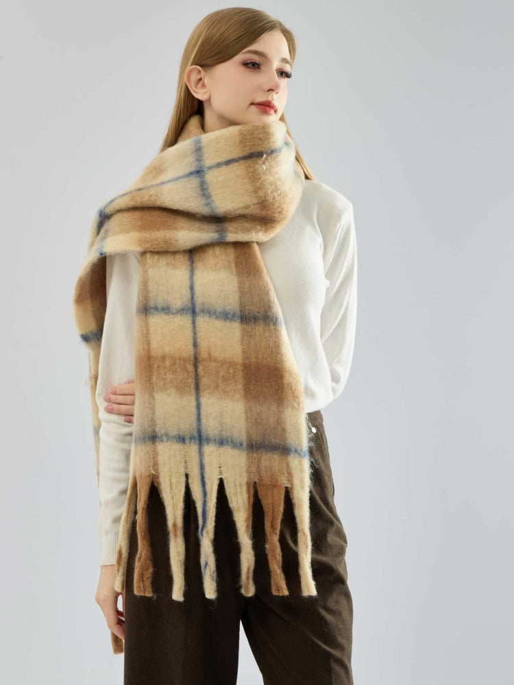 Model wearing a beige and blue plaid scarf draped around her neck