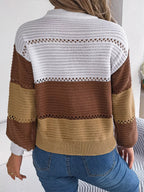 Back view of a woman in a color block knit sweater with open knit details.