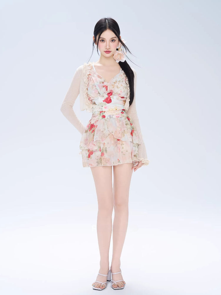 Full body shot of a woman in a floral print tiered dress and sheer cardigan.
