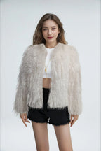 Woman wearing a light grey shaggy faux feather cropped jacket