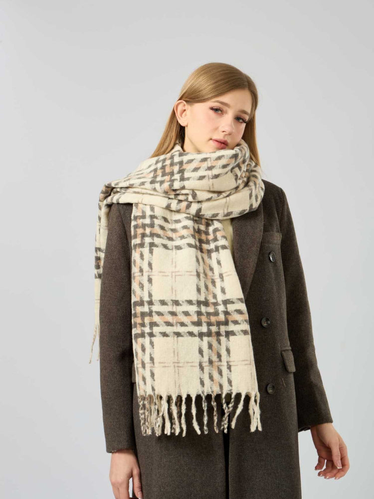 Woman standing with a cream and brown plaid scarf around her neck, showcasing the full pattern.