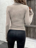 Back view of a woman in a ribbed knit beige turtleneck top.