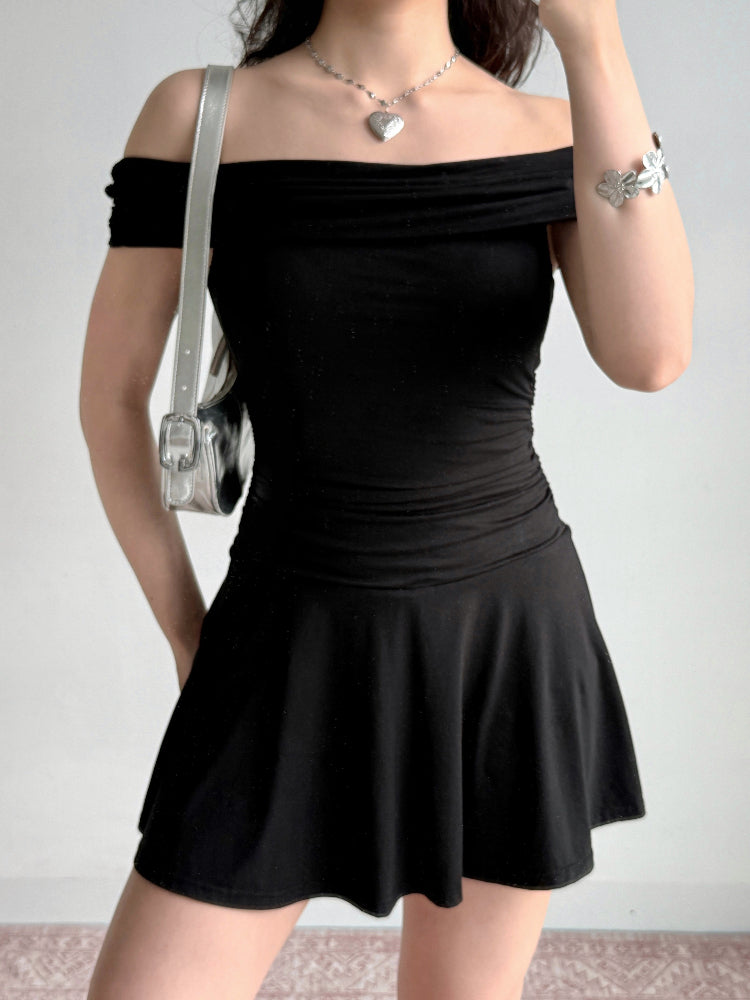 Woman holding a silver handbag and wearing a black off-the-shoulder dress