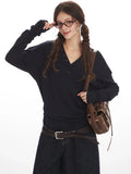 Close-up of a woman in a navy long-sleeve henley shirt and dark wash culottes.