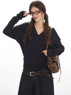 Close-up of a woman in a navy long-sleeve henley shirt and dark wash culottes.