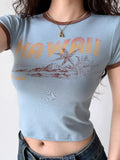 Light blue graphic t-shirt with 'Hawaii' text and tropical island graphic