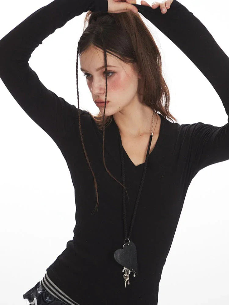 Close-up side view of a woman wearing a black long-sleeve top