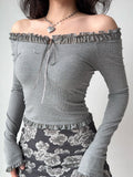 woman wearing a grey off-the-shoulder ribbed knit top with lace trim and a tie closure at the neckline