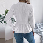 Back view of a white peplum sweater featuring a ribbed texture and long sleeves.
