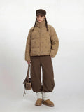 Front view of a woman in a tan corduroy puffer jacket with a dog print.