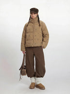 Front view of a woman in a tan corduroy puffer jacket with a dog print.