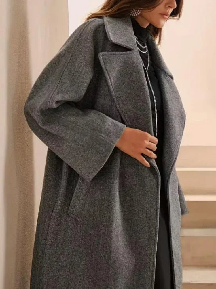Side view of a woman in a grey wool blend coat with wide sleeves.
