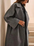 Side view of a woman in a grey wool blend coat with wide sleeves.