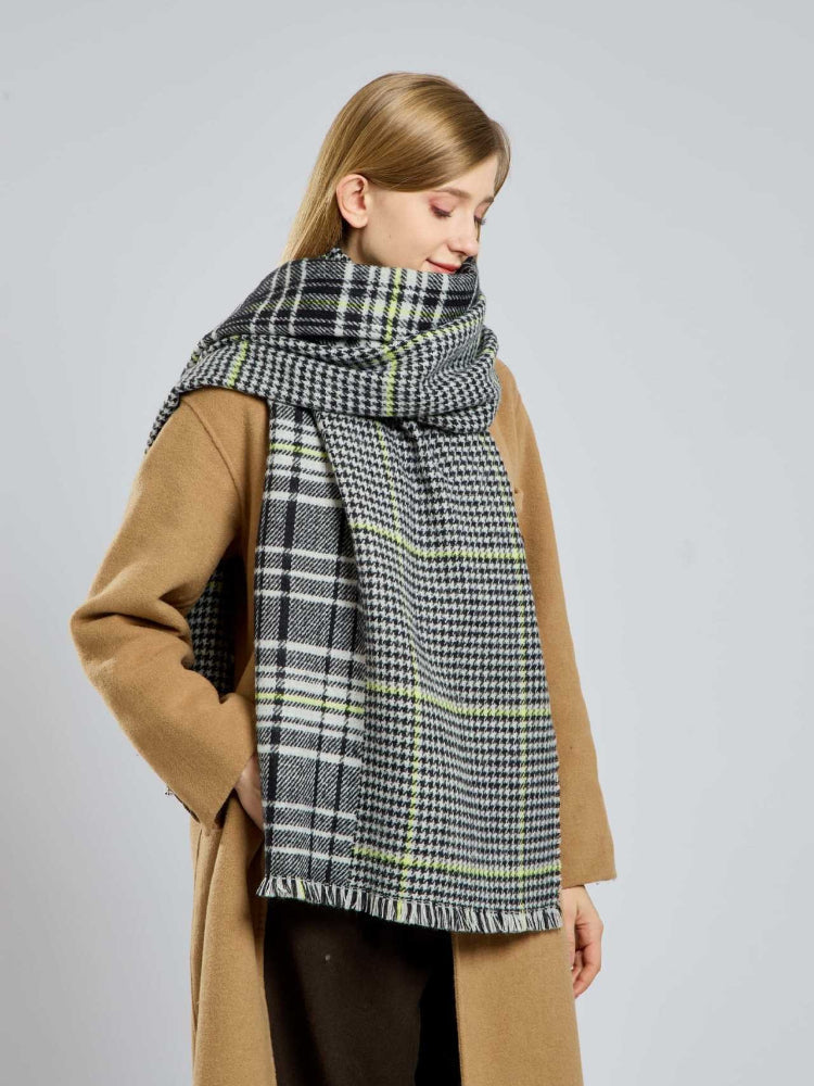 Woman in a camel coat with a black and white houndstooth and plaid scarf.