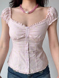 Front view of a pink striped floral print top with gathered fabric at the bust and button details.