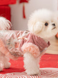 Side view of a white dog wearing a pink dog coat with faux fur trim and floral embroidery