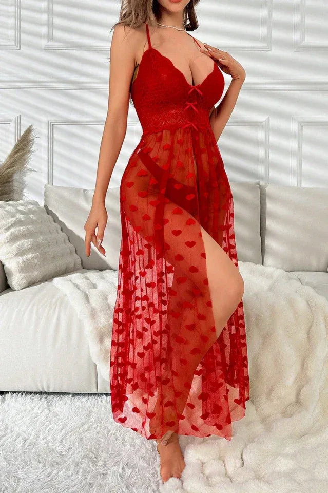 Woman in a red sheer mesh slip dress with heart patterns and spaghetti straps.
