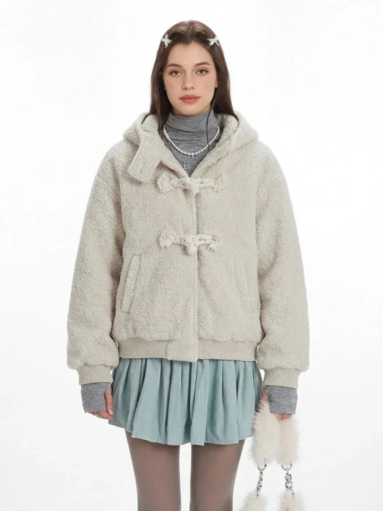 Close-up of the cream fuzzy bomber jacket featuring toggle closures and a textured finish.