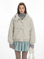 Close-up of the cream fuzzy bomber jacket featuring toggle closures and a textured finish.