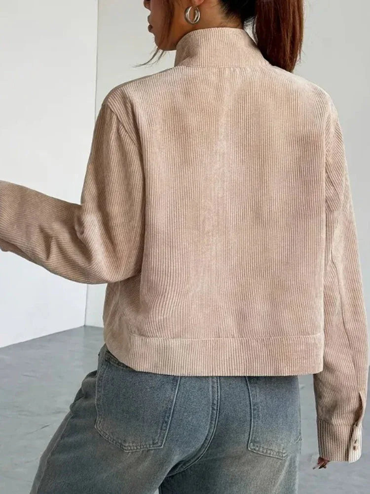 Back view of a woman in a beige corduroy cropped jacket.
