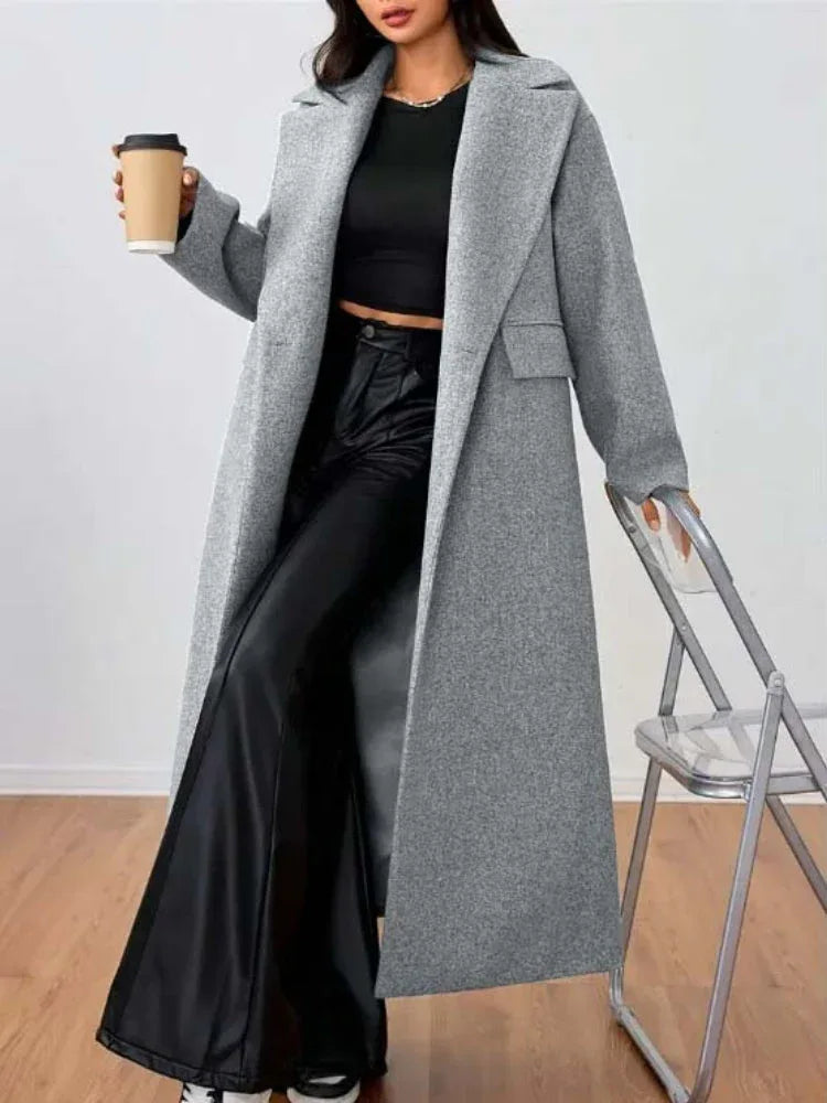 Woman wearing a grey longline wool blend coat with notched lapels, holding a coffee cup. Main image